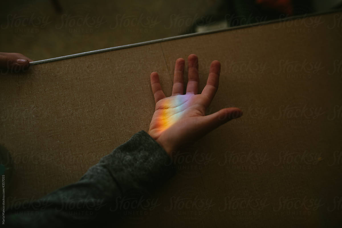 hand in rainbow light beam