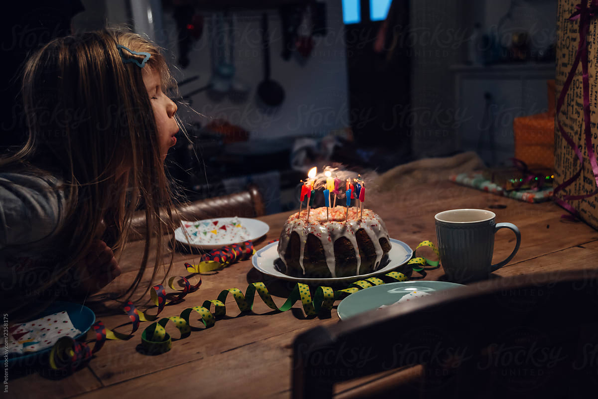 Girl Blows Out The Candles On A Birthday Cake By Stocksy Contributor girl-blows-out-the-candles-on-a-birthday-cake-by-stocksy-contributor