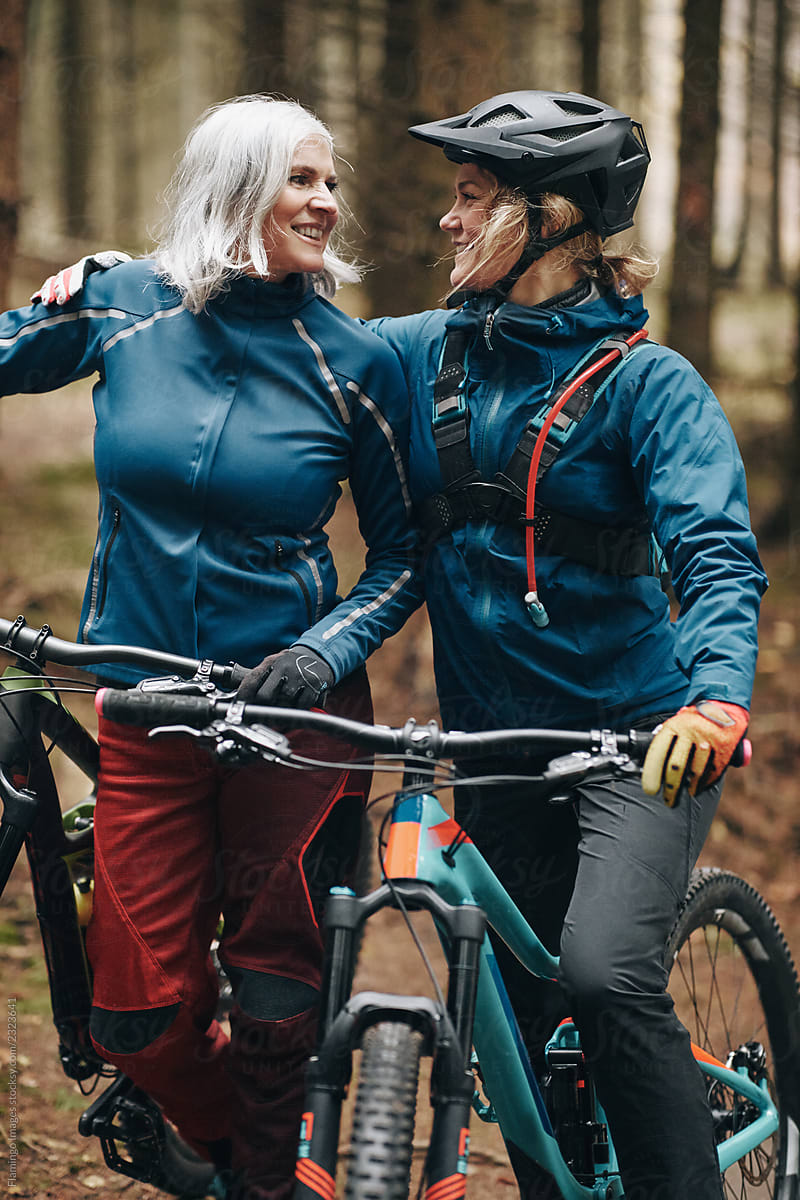 Smiling daughter and mother out for a mountain bike ride