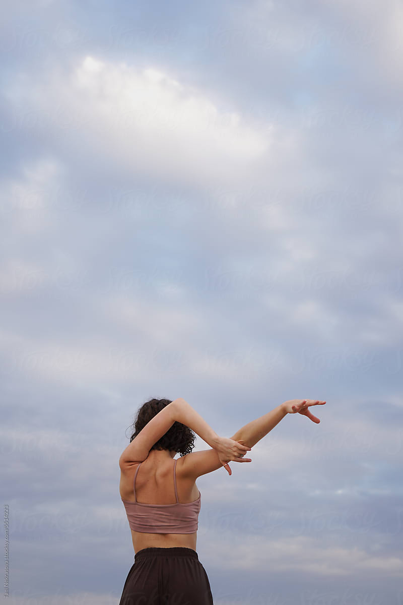 Woman On The Beach By The Ocean Doing Yoga