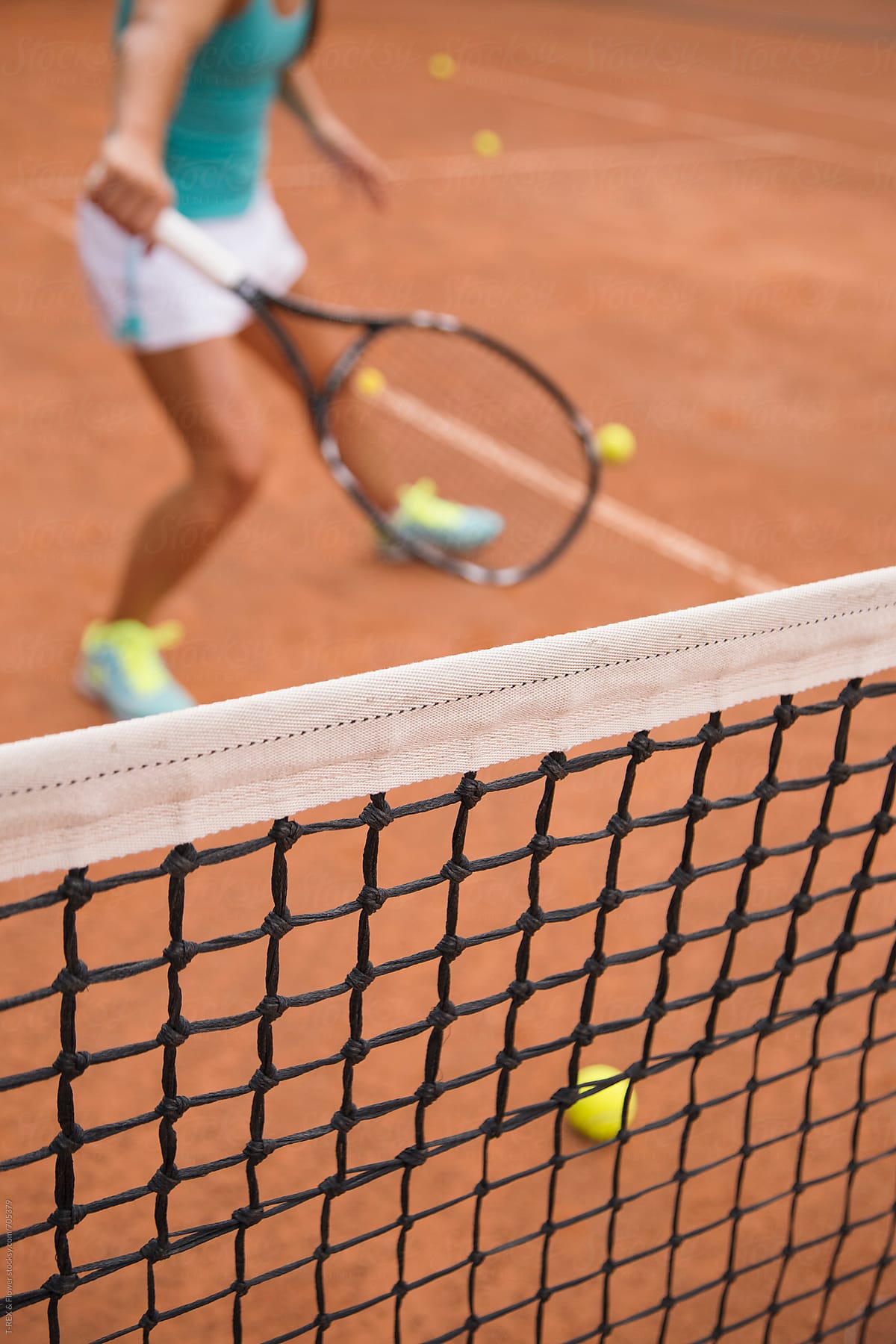 Closeup of the tennis net and silhouette of the player