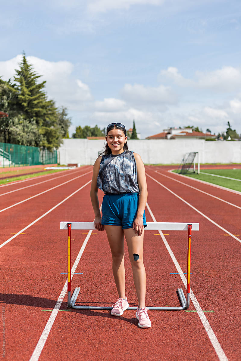 A young woman dressed in sportswear posing in an athletics track
