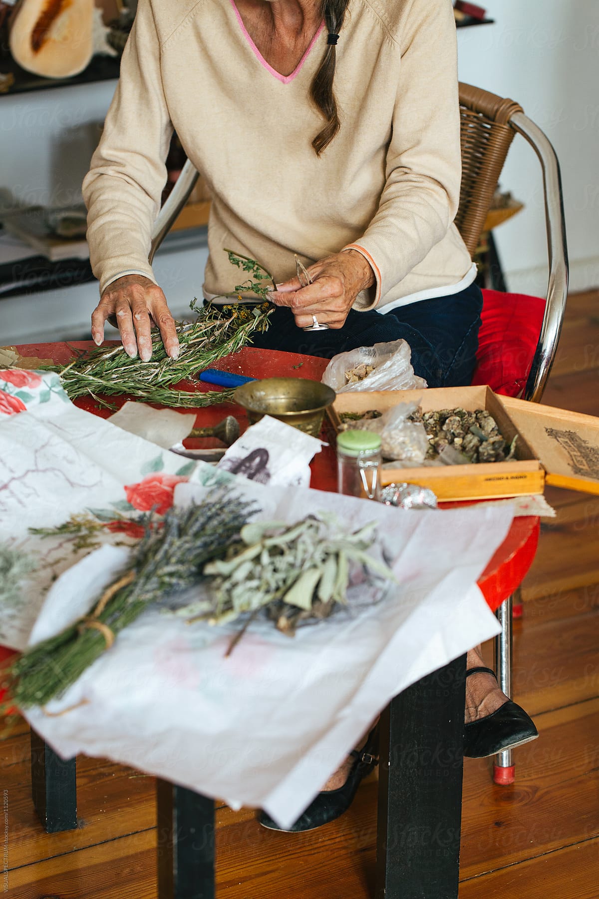 Closeup of Elderly Woman Making Natural Smudge Stick With Dried Herbs