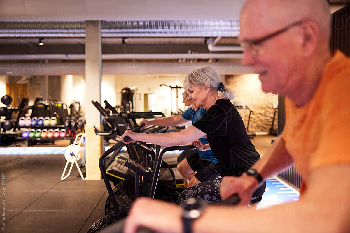 Seniors riding stationary bikes at the gym