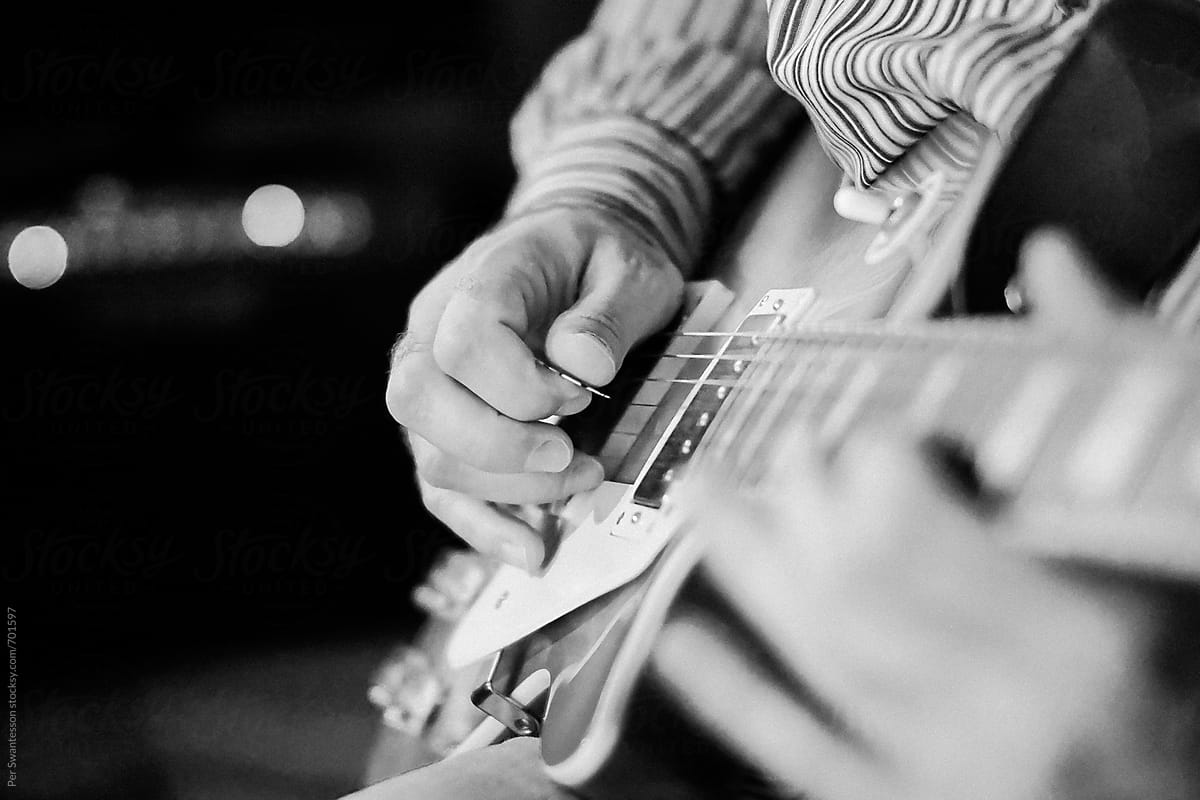 Closeup of man practicing playing on an electrical guitar