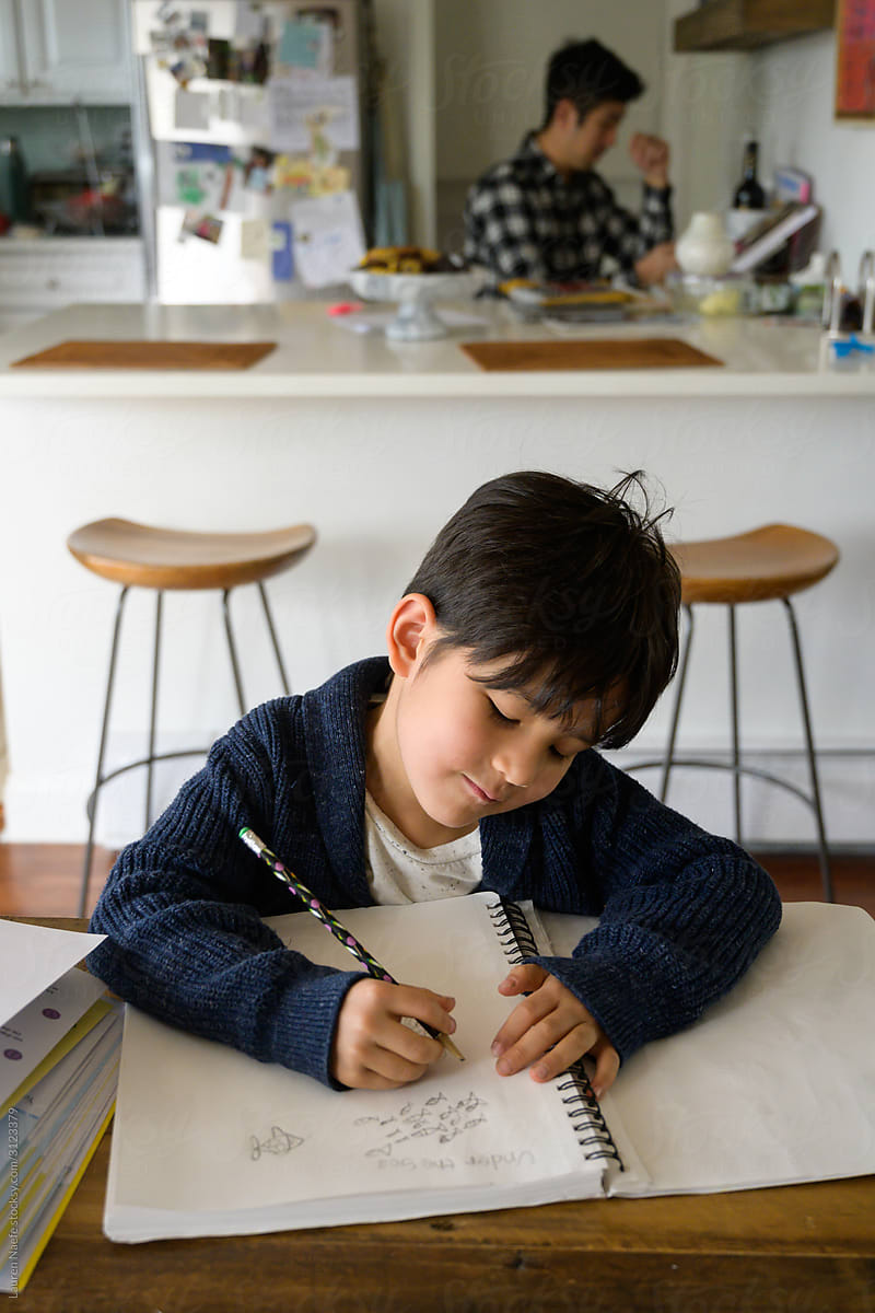 Child drawing at kitchen table