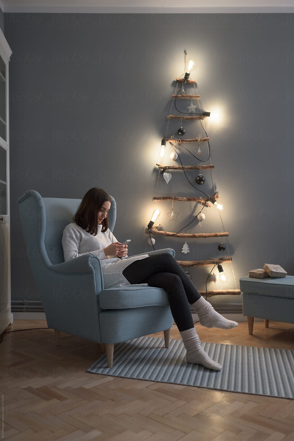 Woman relaxing in the living room by the Christmas tree
