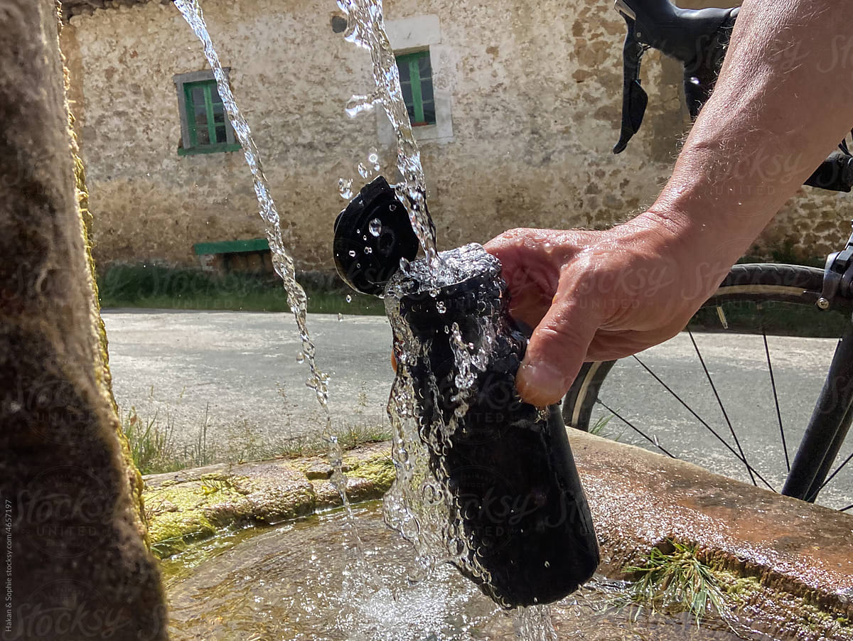 Filling a water bottle at a local old fountain on a ride