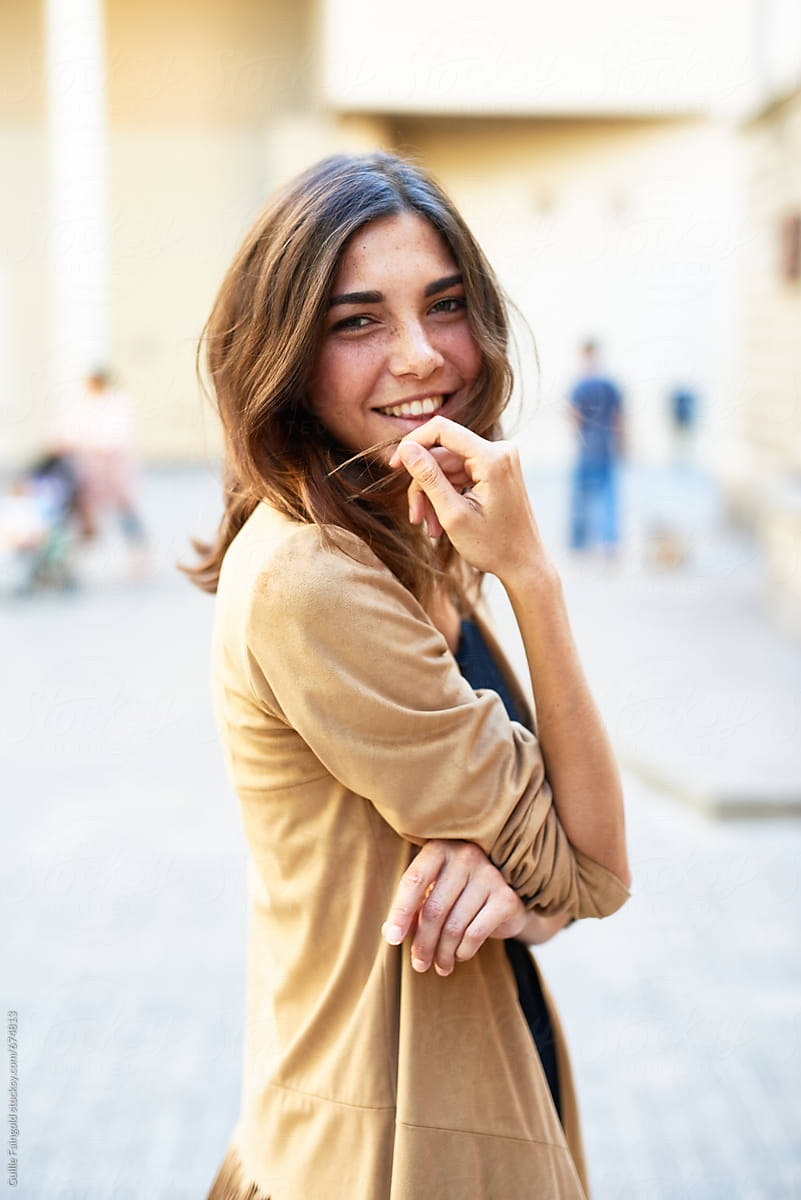 Cheerful Pretty Girl Smiling At Camera In The Street By Stocksy Contributor Guille Faingold