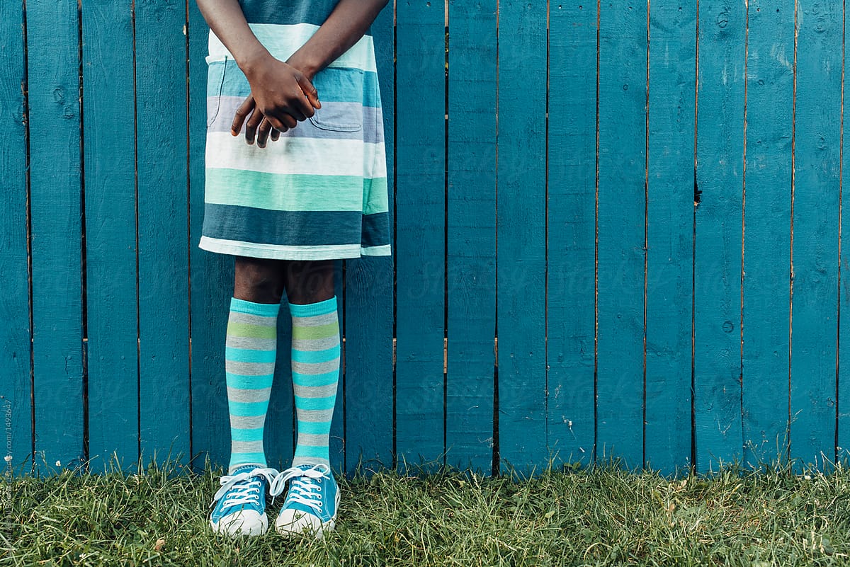 African American girl\'s legs wearing knee-high socks and tennis