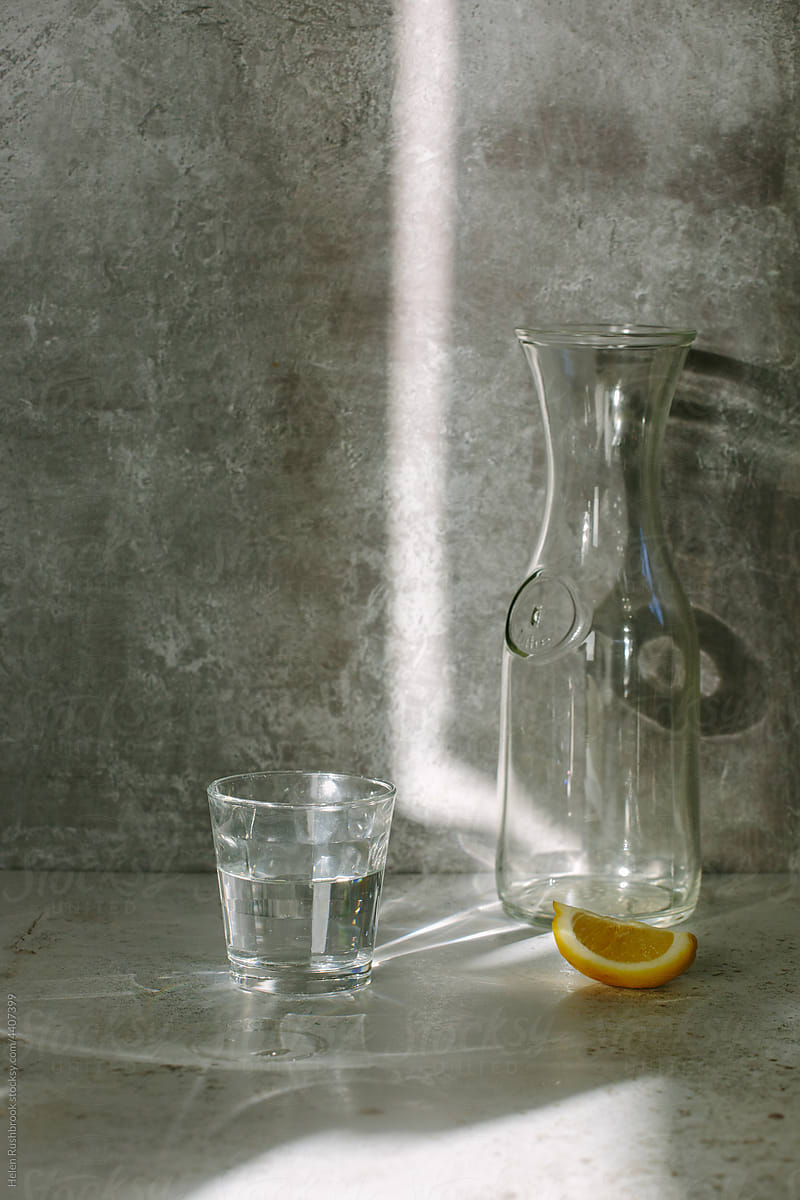 Glass of water and lemon in sunlight.