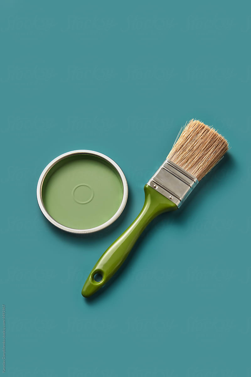 Green lid of paint with clean brush