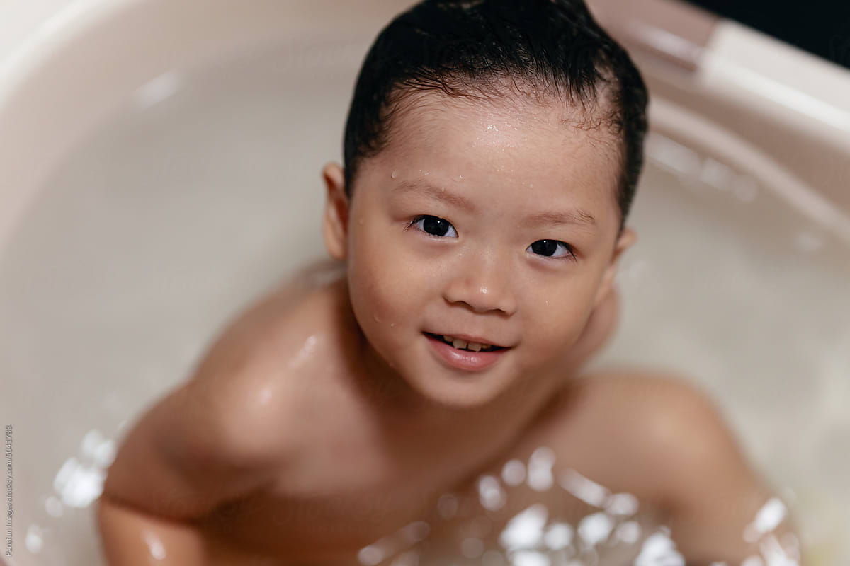 Adorable happy little kid in bath tub