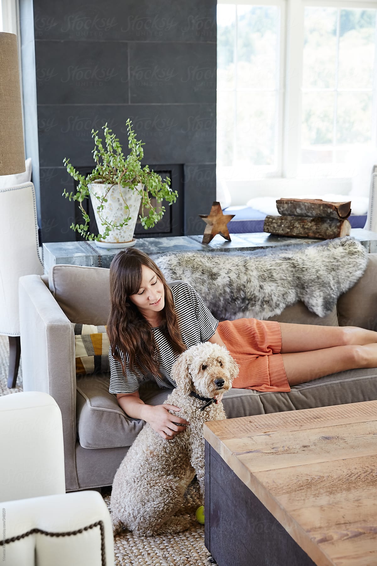 Woman relaxing in her living room with her dog