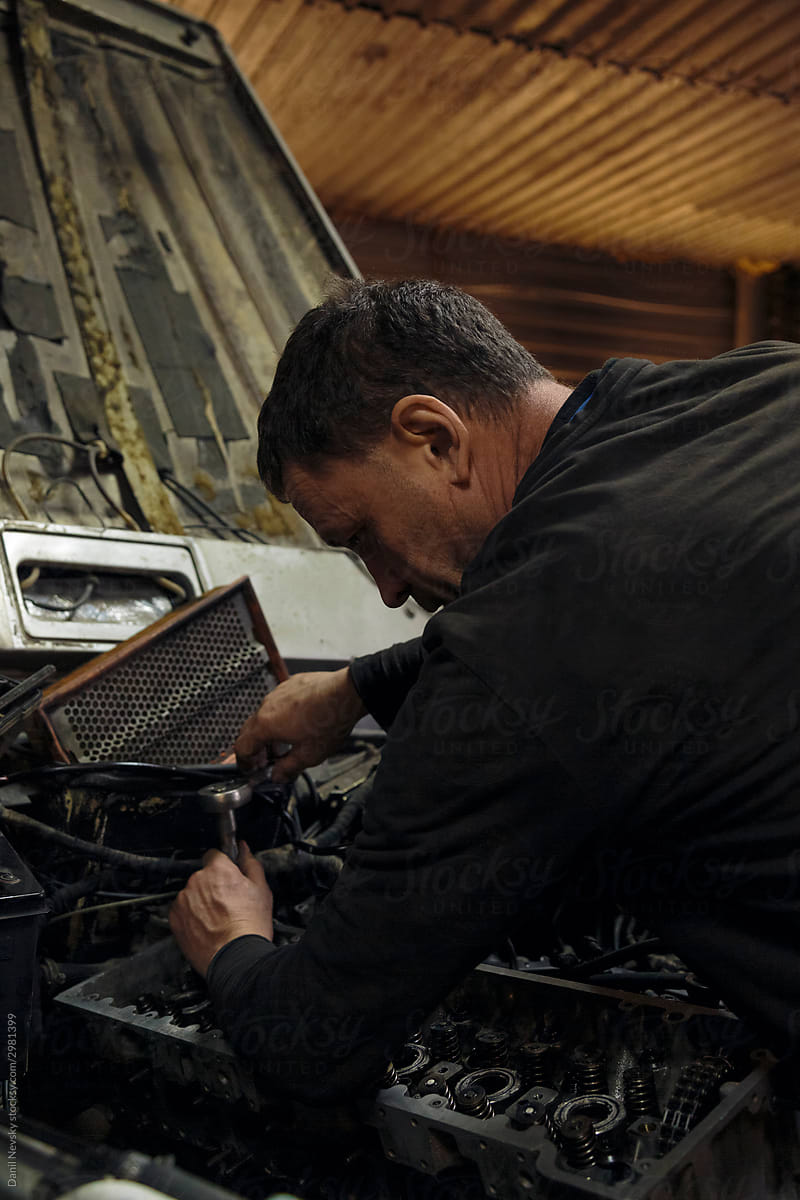 Adult mechanic fixing car engine