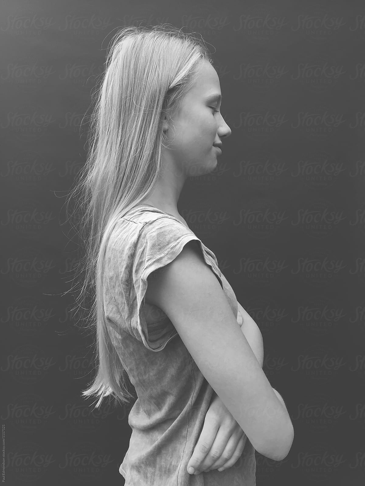 Portrait of teenage girl with eyes closed and arms crossed