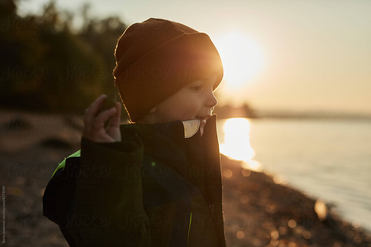Little Boy Playing Outdoors At Sunset