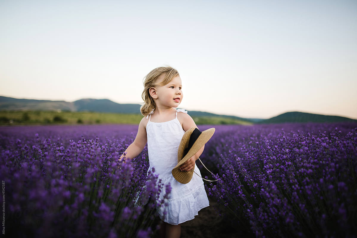 Cute little girl in field with blooming lavender