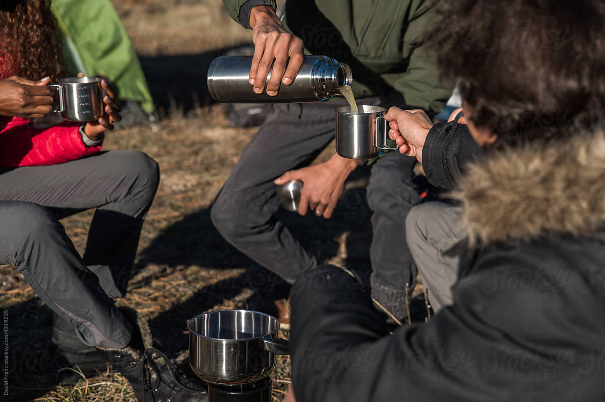 Diverse hikers drinking soup from thermos