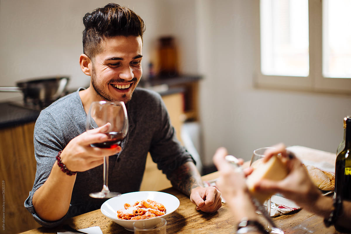Delighted man having romantic dinner at home