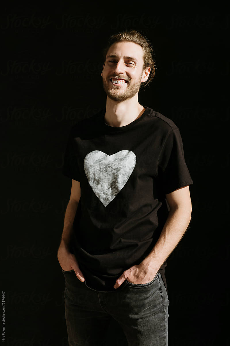 Modern happy man in black T-shirt with love heart symbol.