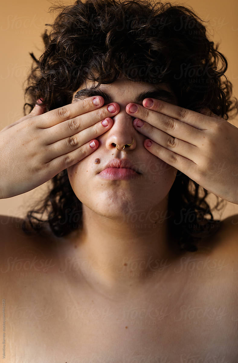 Trans woman covering her eyes portrait