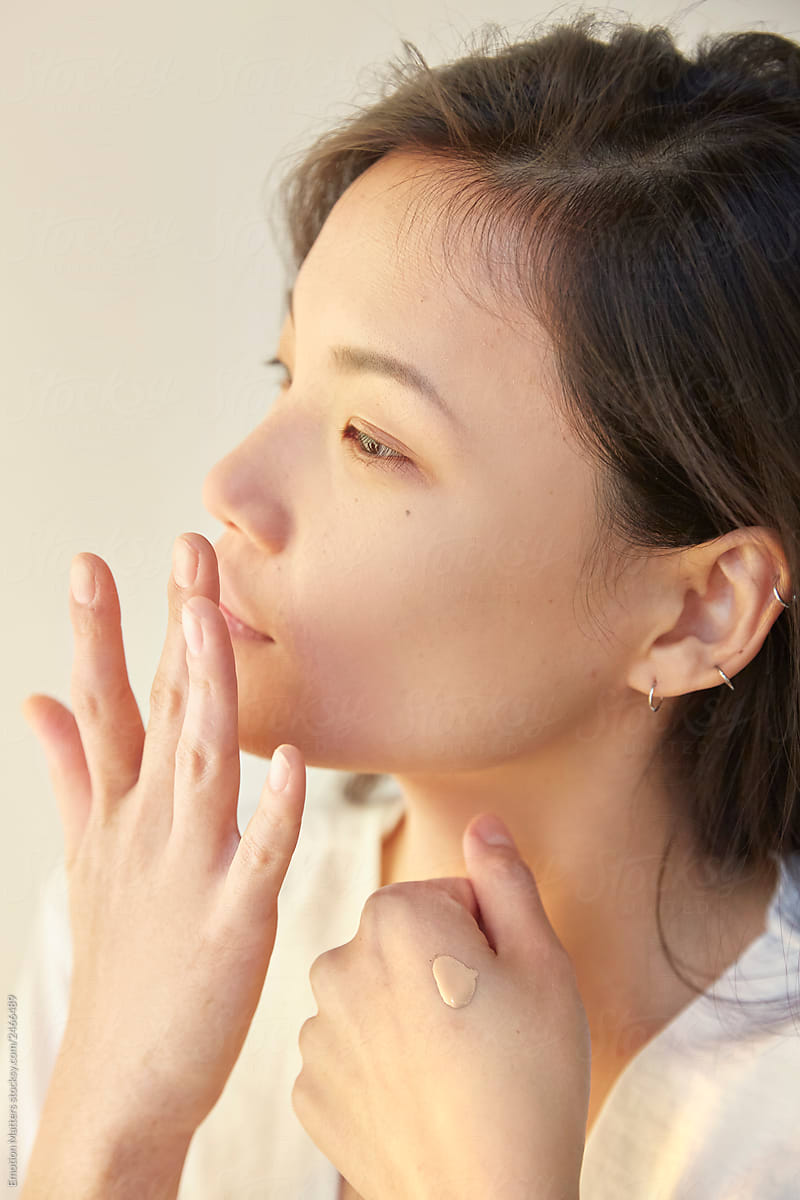 Profile view of a woman applying makeup