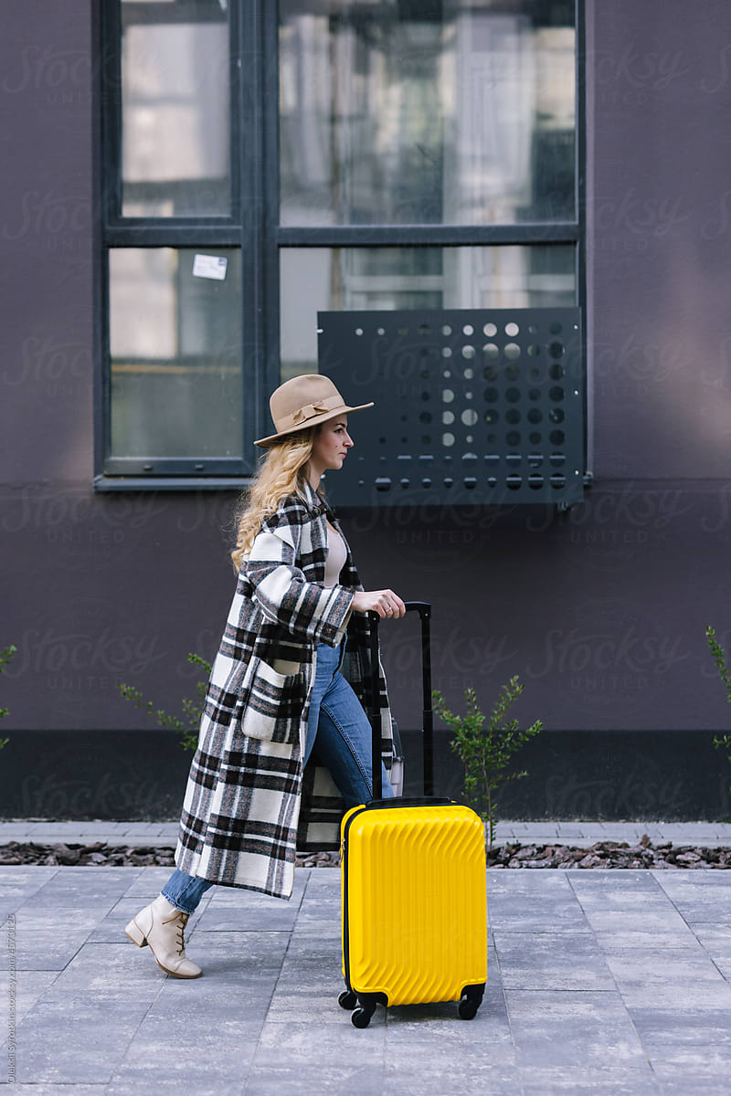 Woman strolling outdoor with luggage