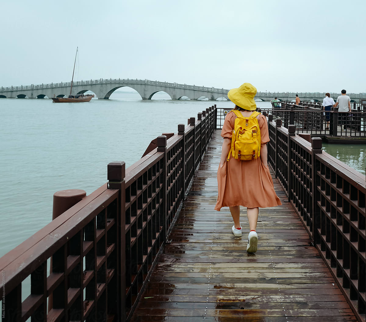 Back view of woman walking on Chinese bridge