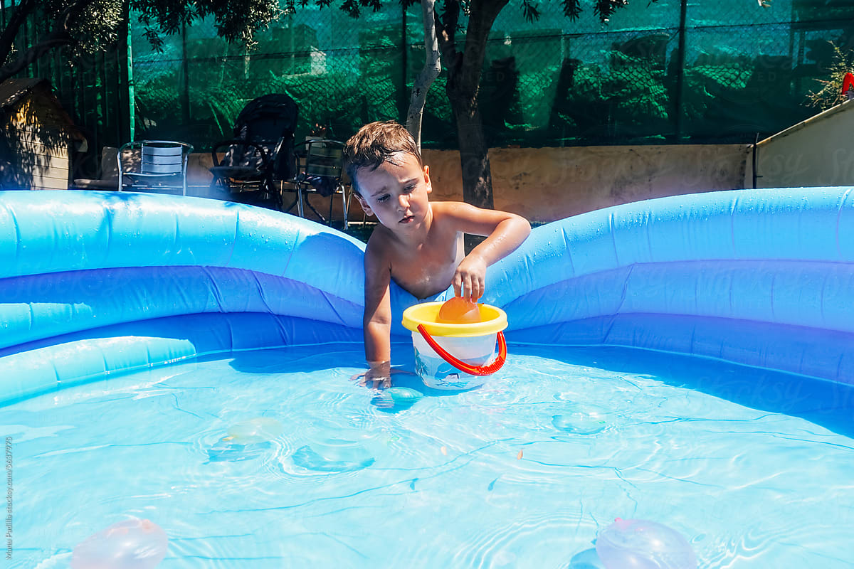 Boy with bucket playing in swimming pool