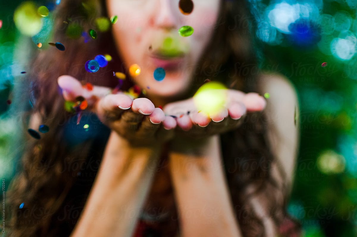 A Young Woman Blowing Glitter Confetti Del Colaborador De Stocksy 