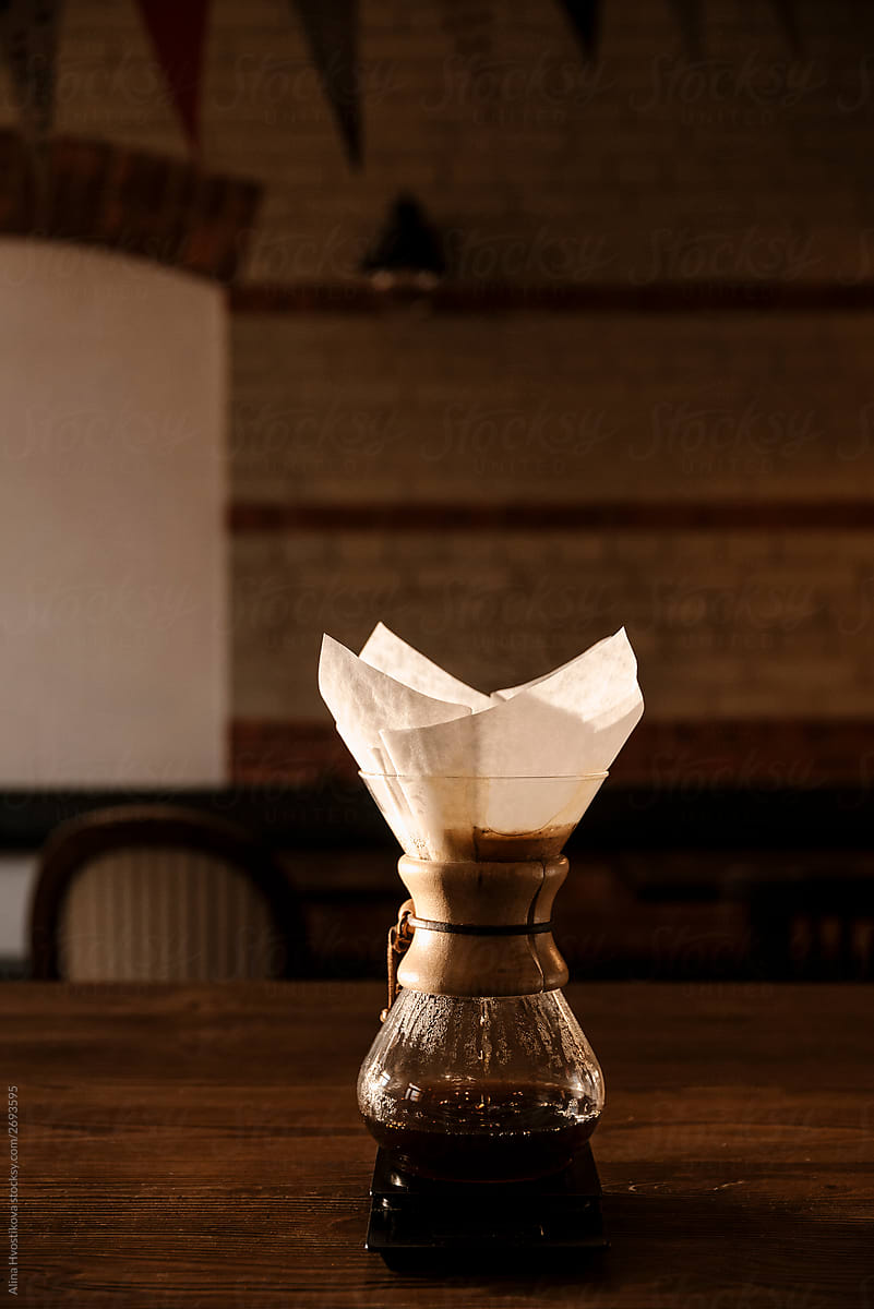 Glasses pot with v60 coffee on wooden table.