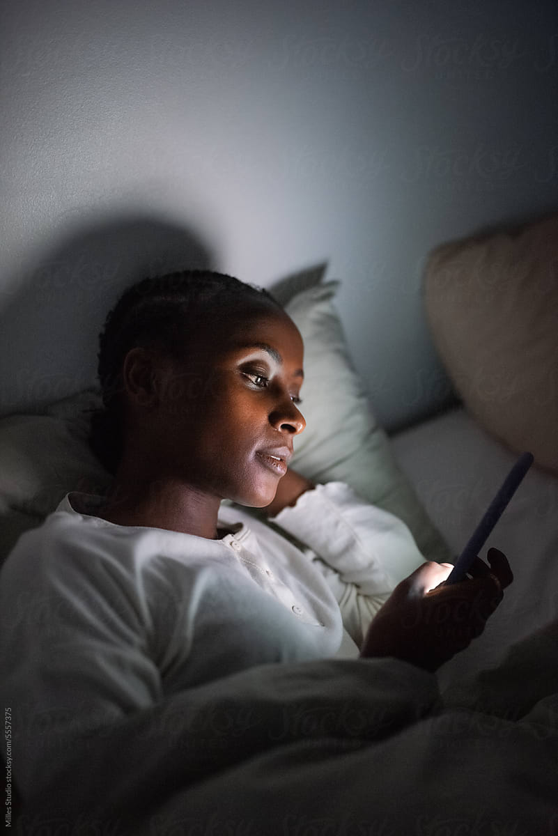 Woman watching videos on cellphone while staying awake