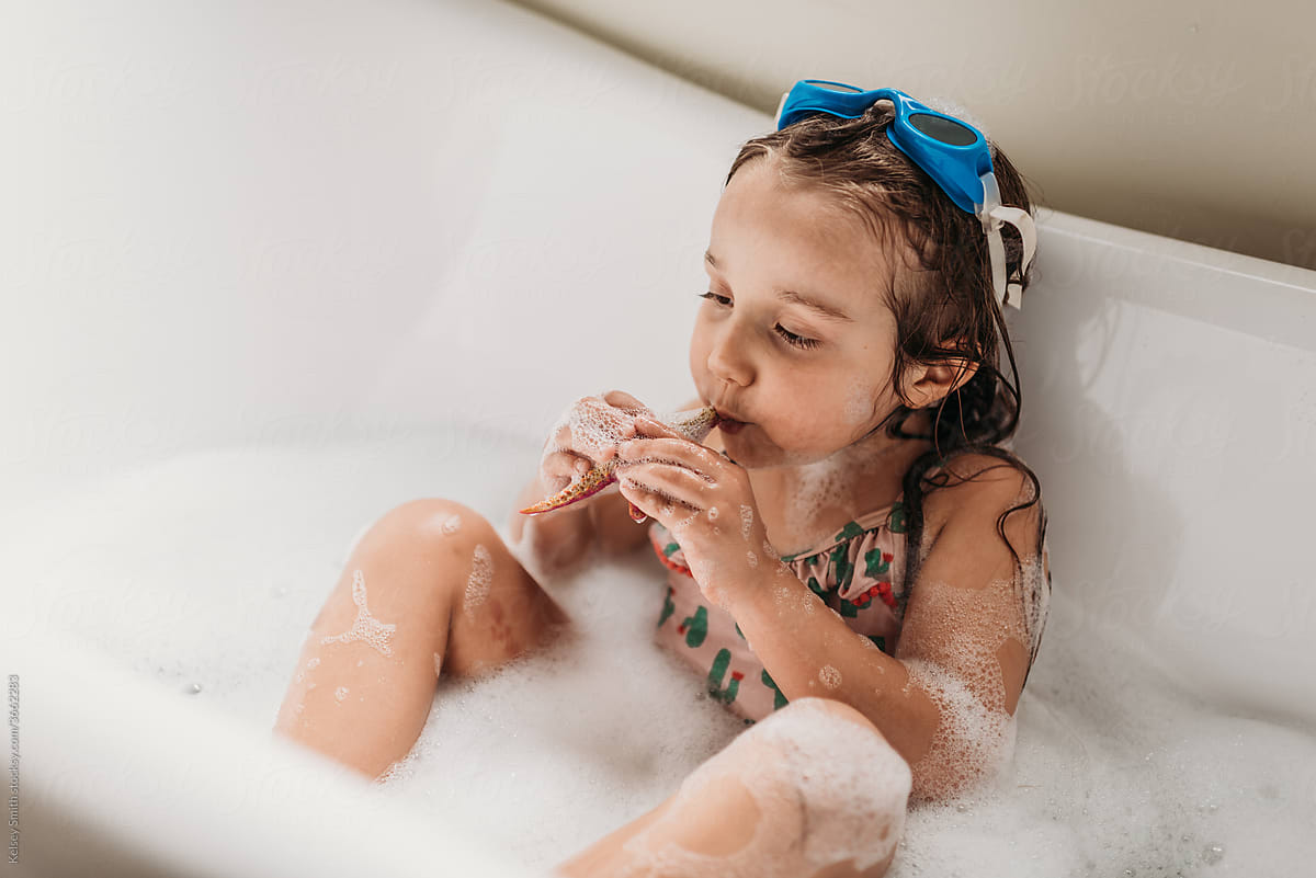Girl kissing toy in tub