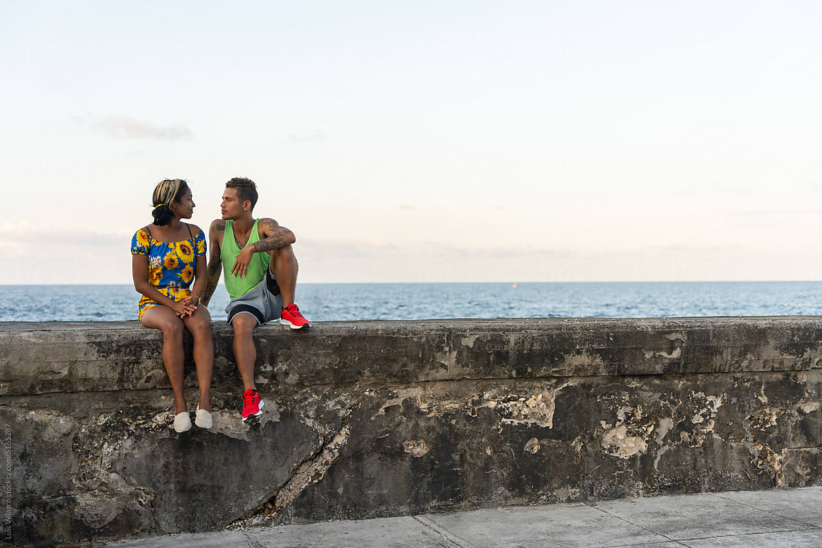 Two Young People Flirt On A Boardwalk