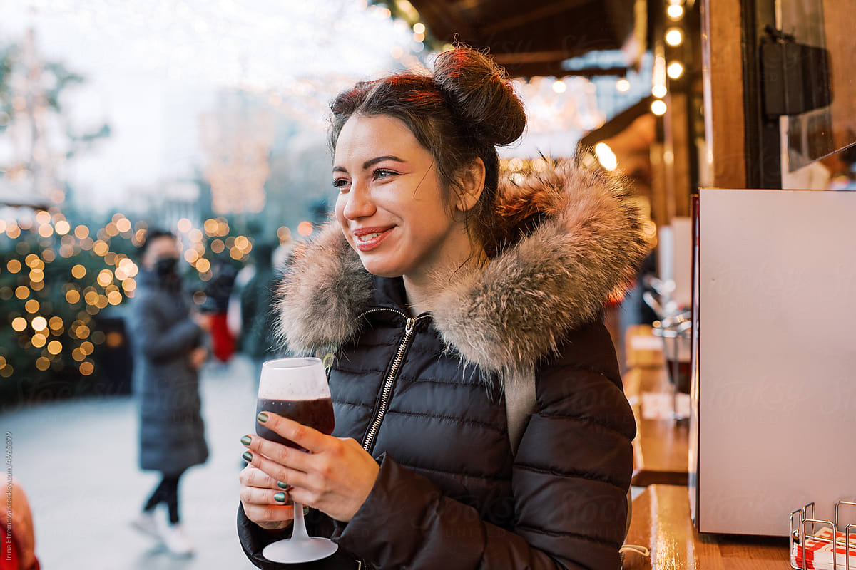 Woman enjoying Mulled Wine with her family on Christmas Market