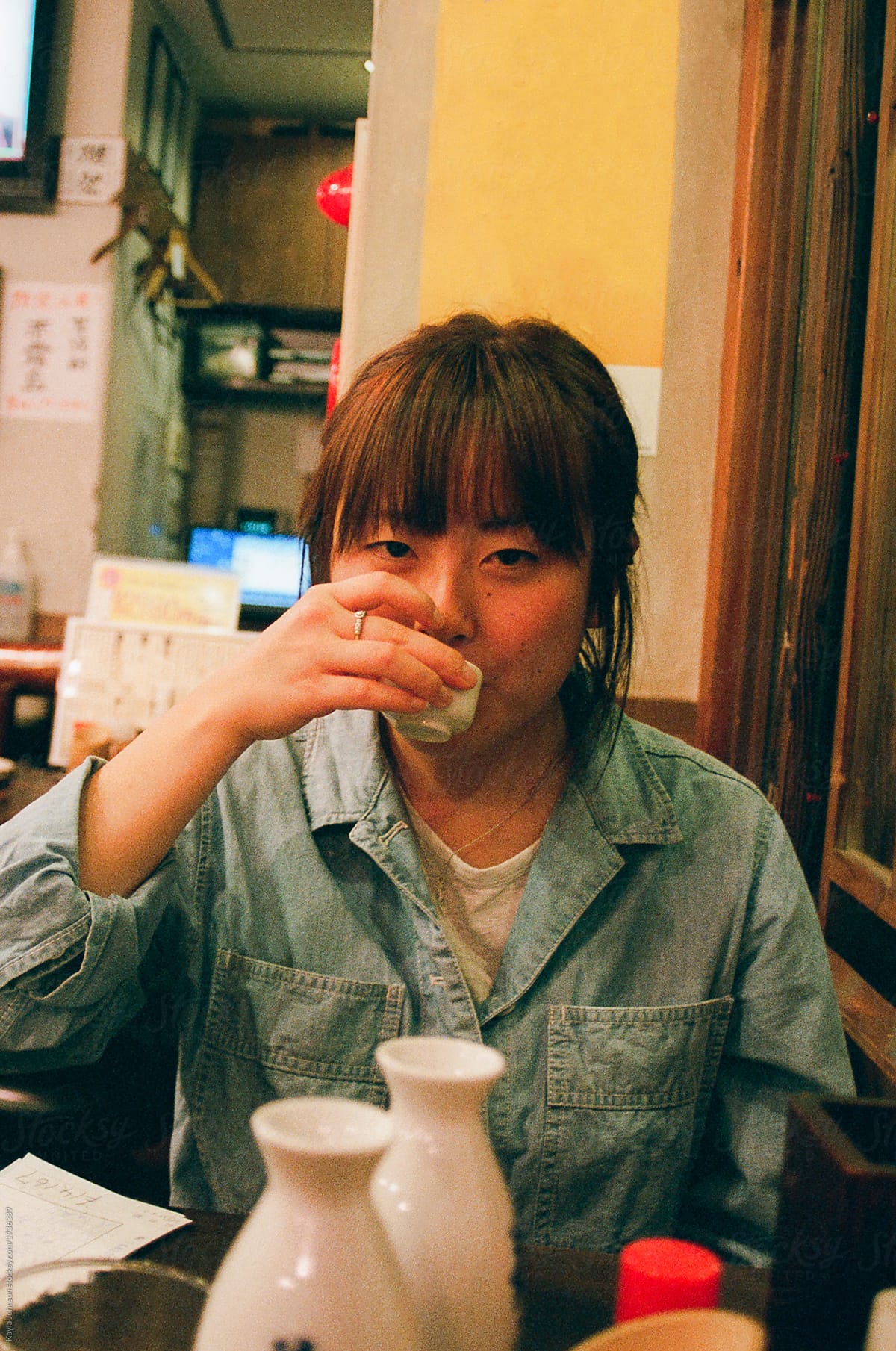 Sultry Japanese woman drunkenly sipping sake