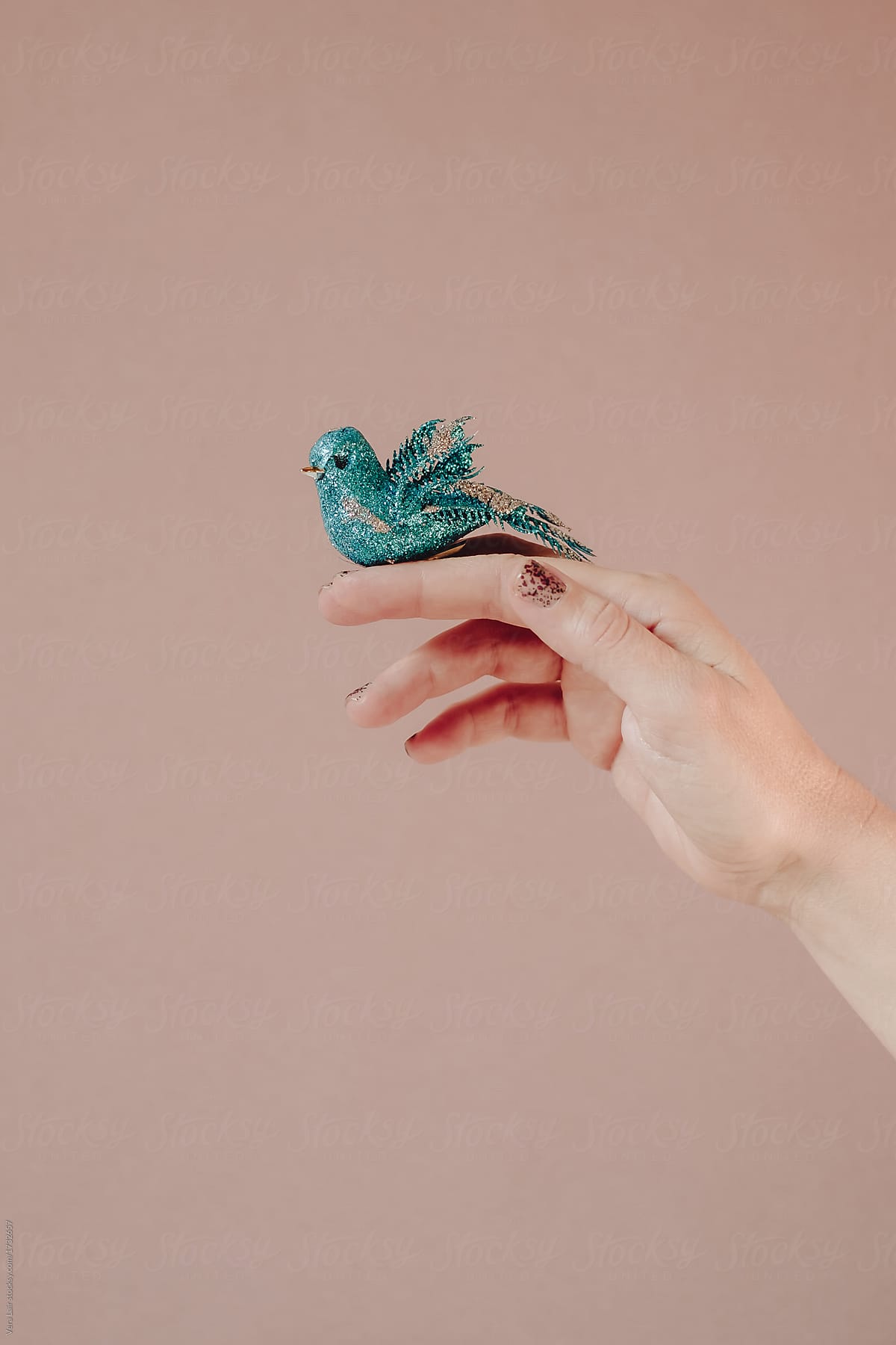 Hand holding a small fake bird