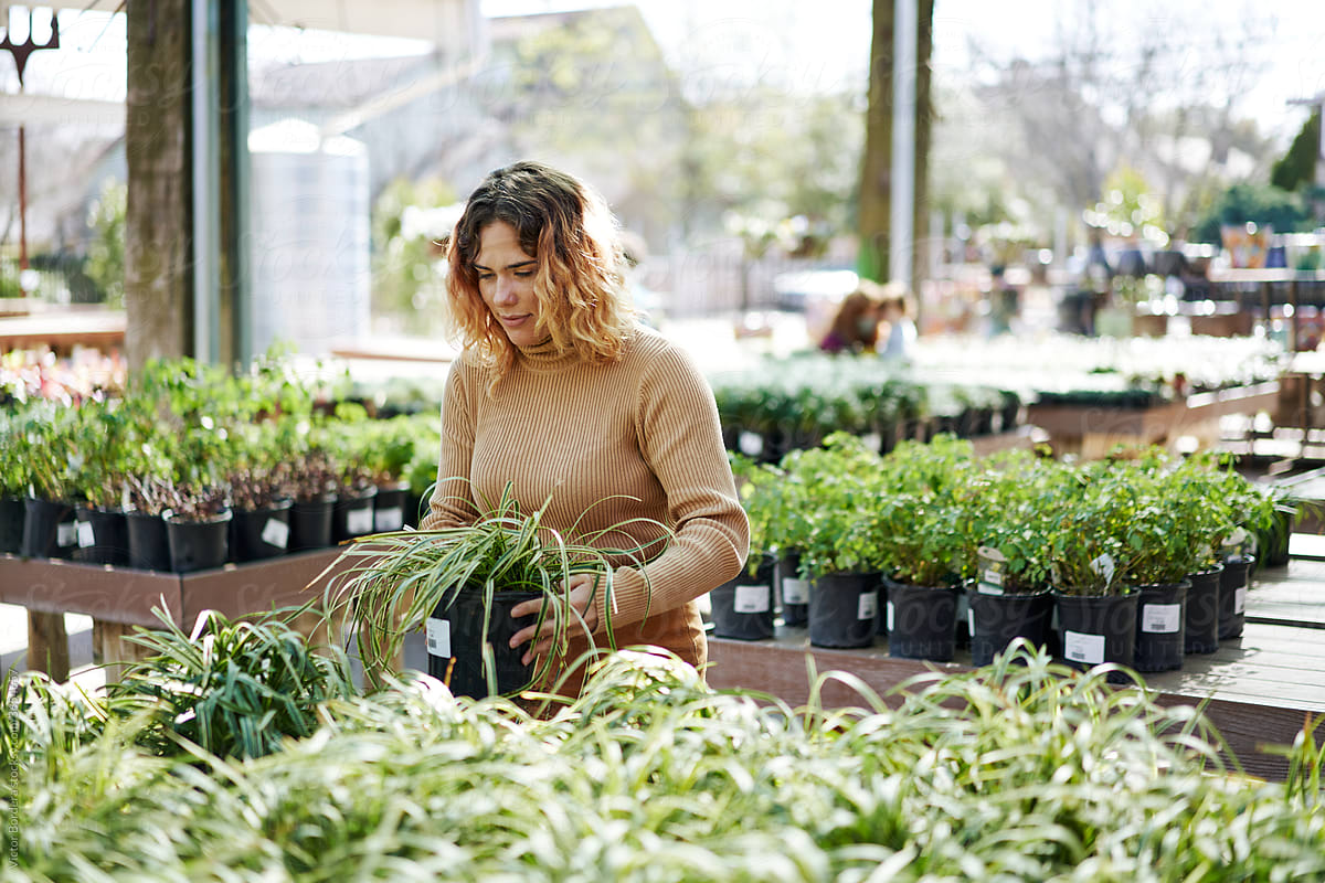 American woman selecting a plant in a local business.