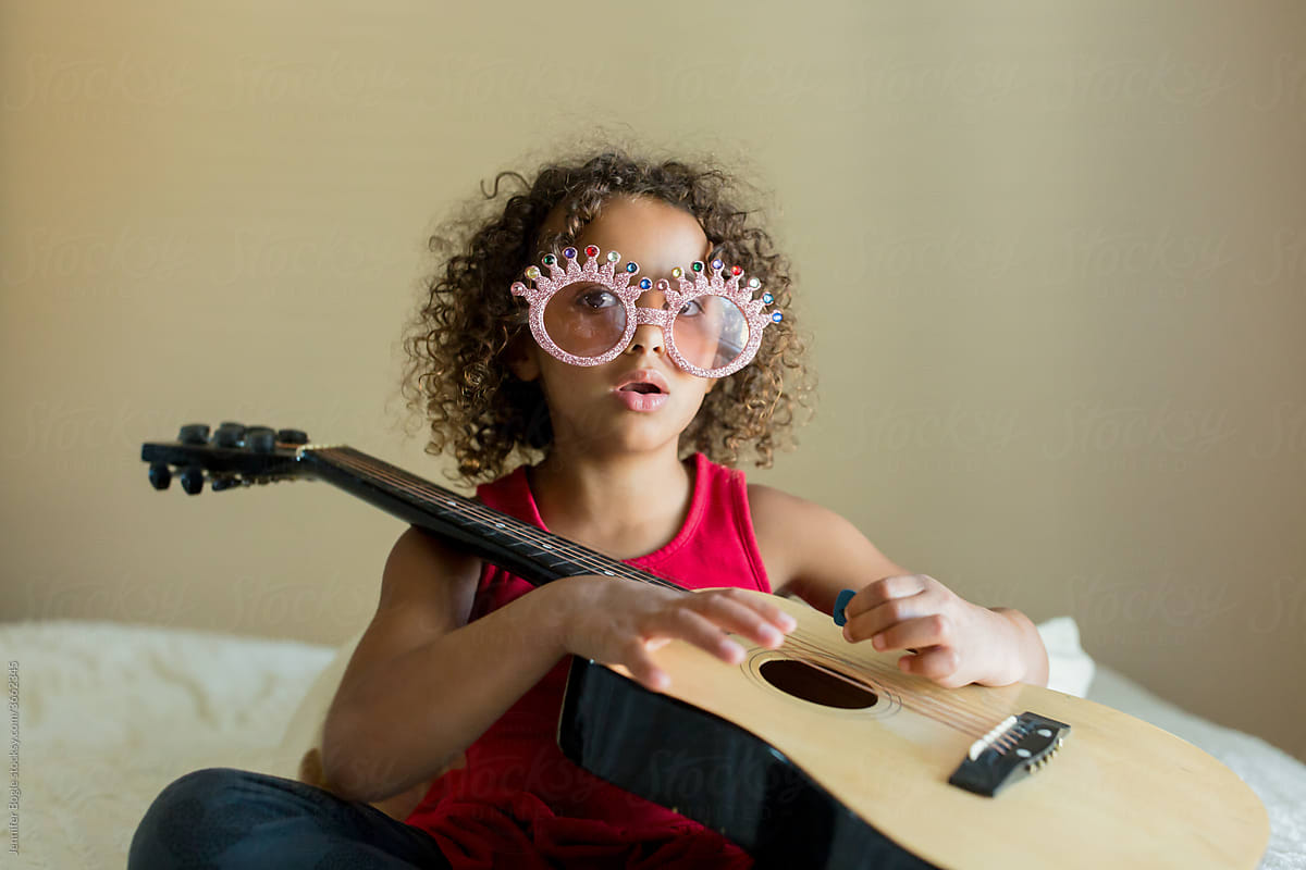 curly haired girl with guitar and novelty glasses