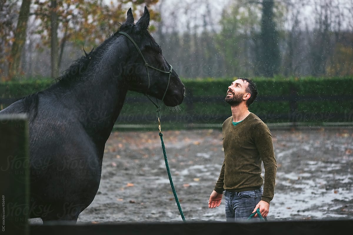 Man and horse under the rain