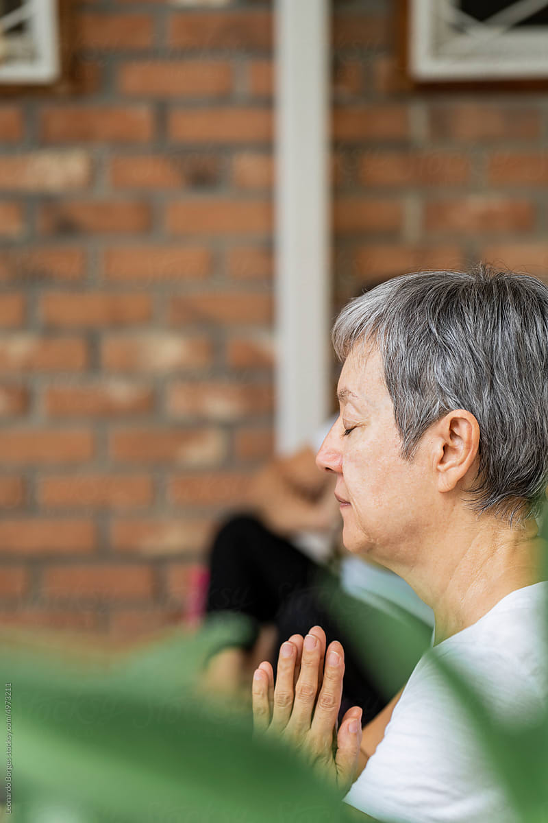 Older adult student making mudras in yoga class