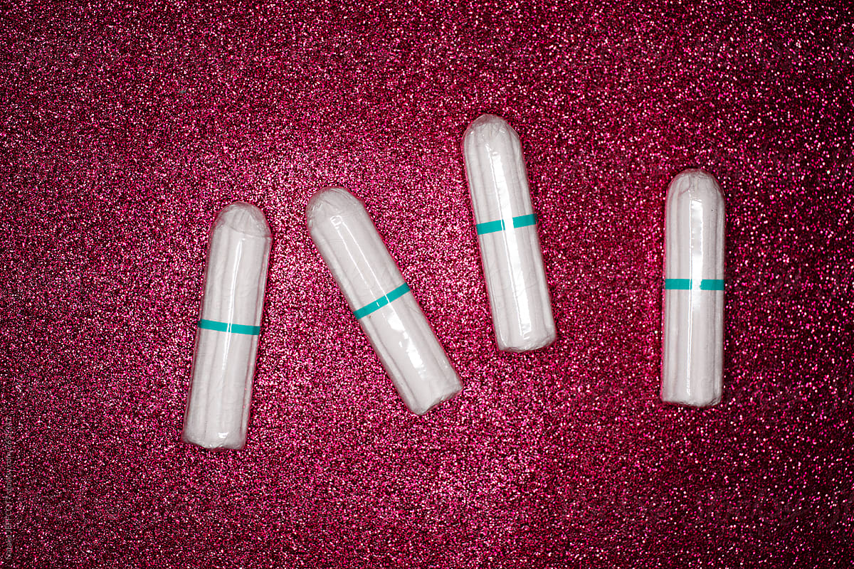 Concept for menstruation - cotton tampon on pink glitter background