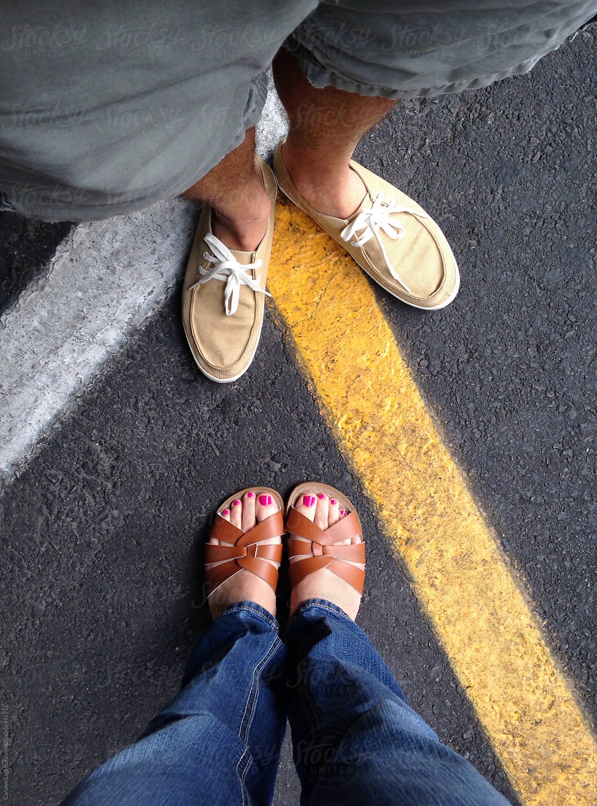 Couple\'s feet at what seem to be a crossroads