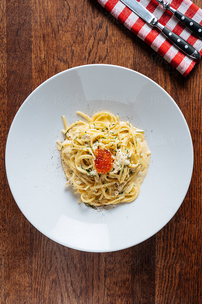 Plate with delicious pasta on wooden table