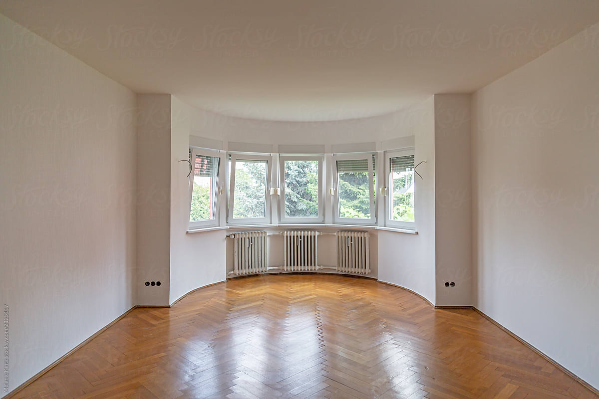 Empty Room with large bay window and hardwood floor after renovation