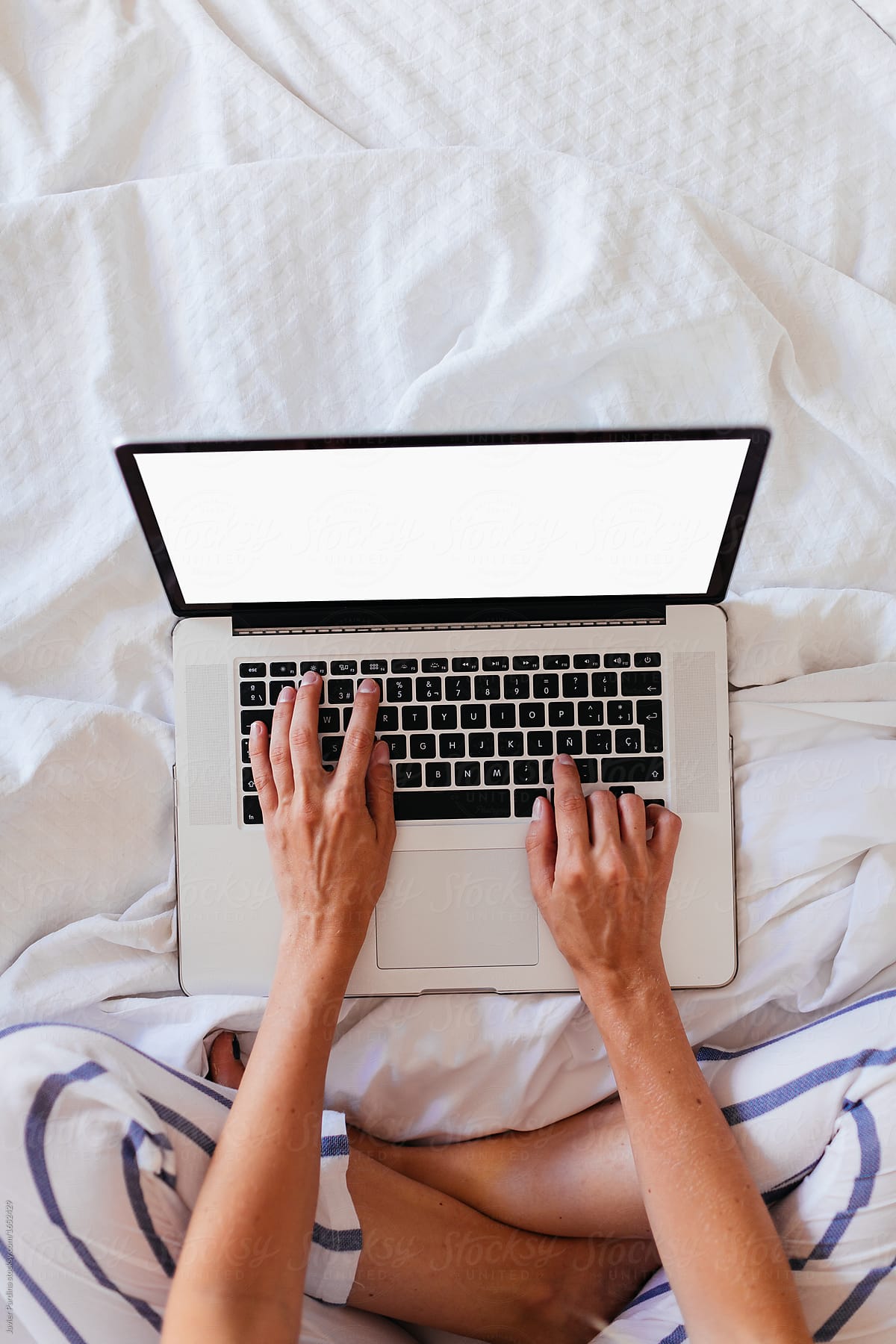 Woman working  with laptop on the bed