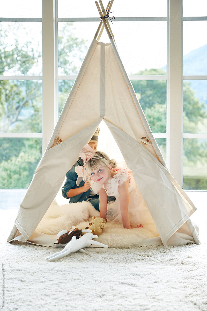 Kids playing in teepee tent together in living room
