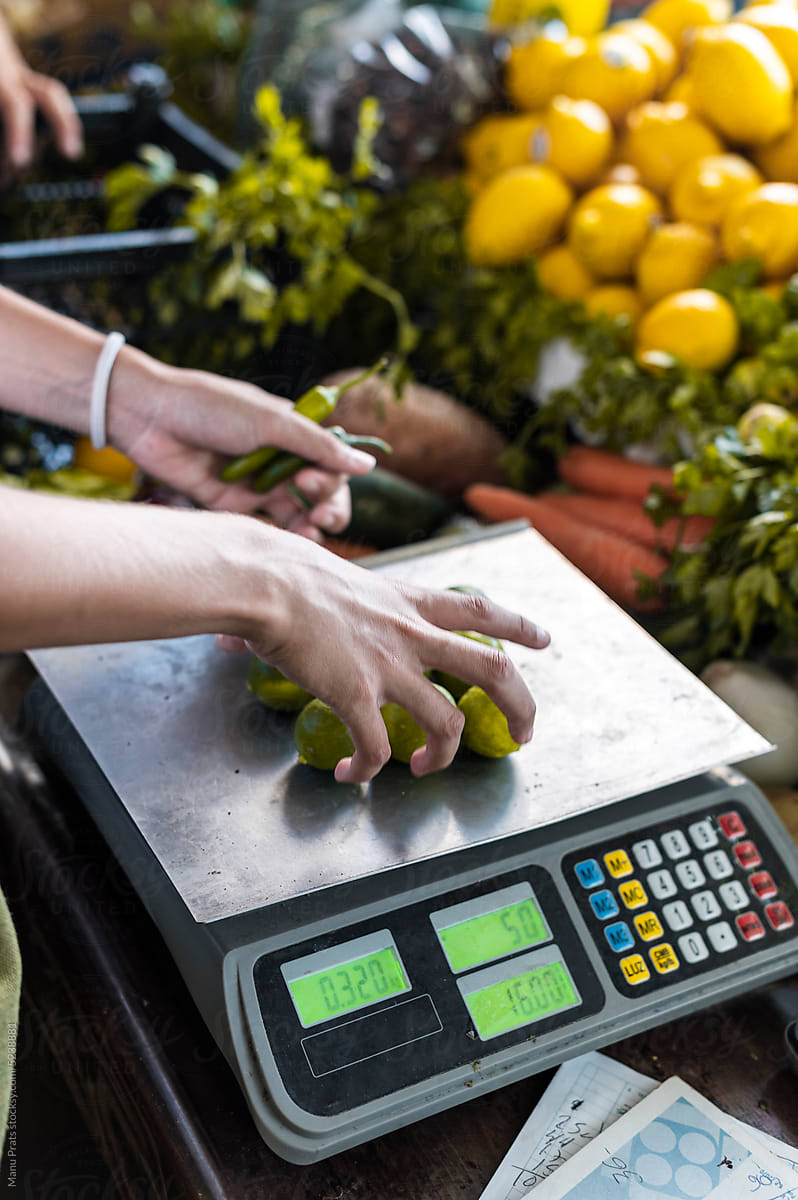 Bunch of limes in weighing scale on vegetable store