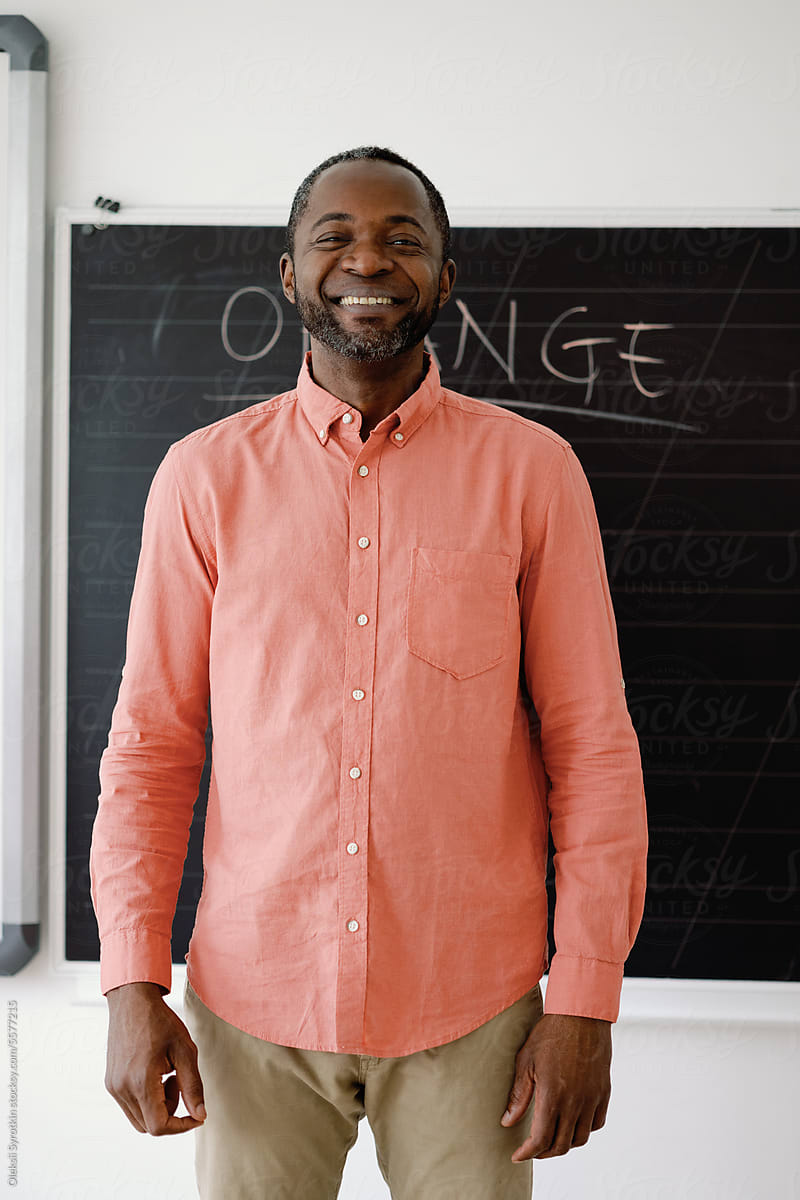 Man in shirt smiling brightly in classroom